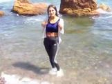 Girl in sportswear gets wet in the sea